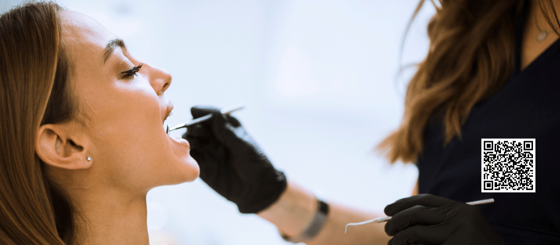 A dentist checking her patient's mouth for oral cancer.